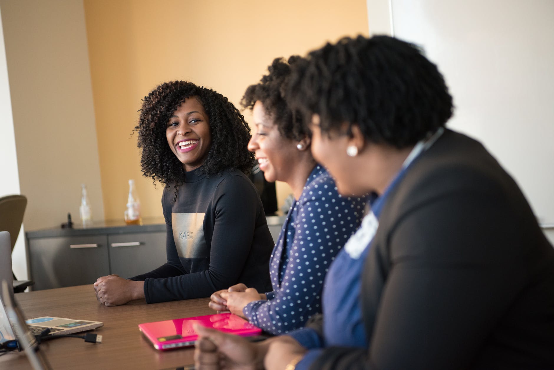 smiling woman leaning on table. smart money bro.