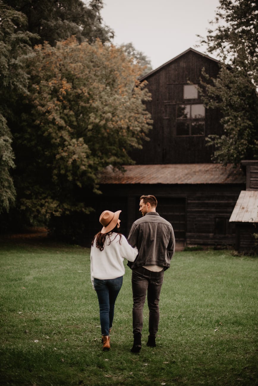 man and woman standing on green grass. smart money bro