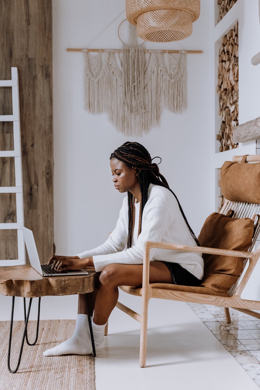 woman in white long sleeve shirt sitting on brown wooden chair, smart money bro